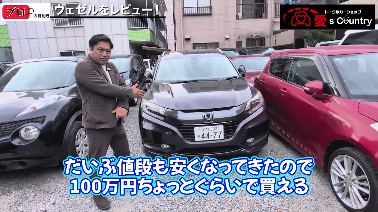 社長がホンダ・ヴェゼルの前で価格を紹介する様子