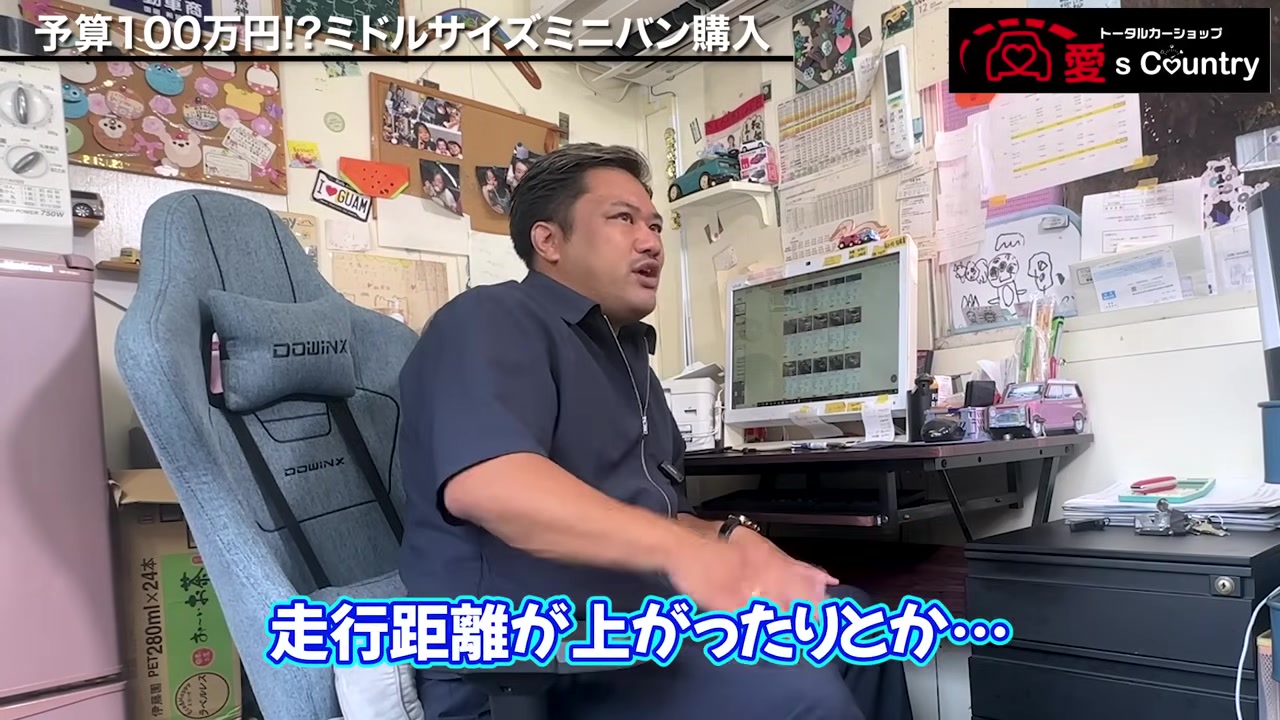 事務所で予算100万円のミニバン選びを解説する国岡社長