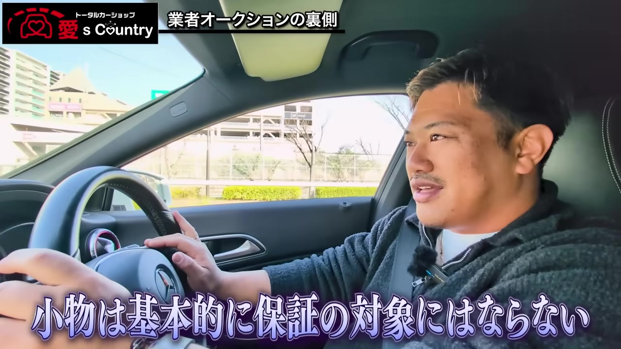 車内でオークションの保証ルールを解説するくに社長