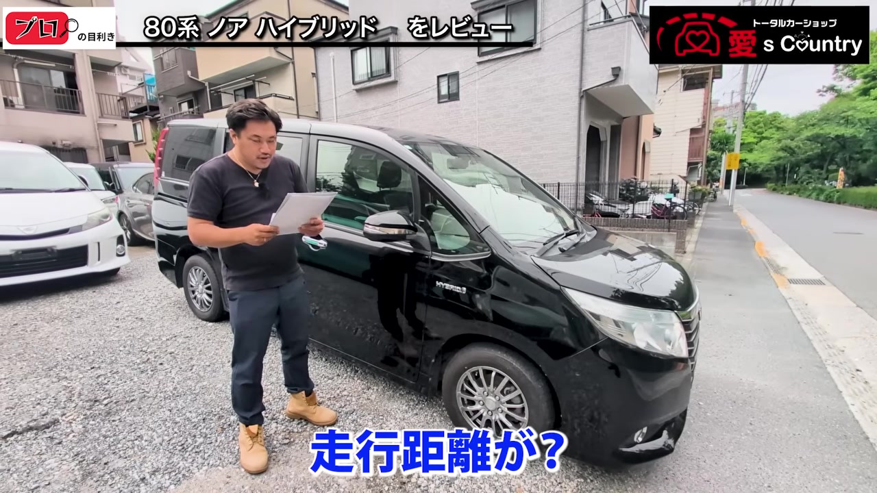 黒いノアの横で走行距離を確認するくに社長