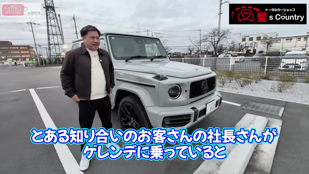 淡いグレーのメルセデスAMG G63の前でレビューするくに社長