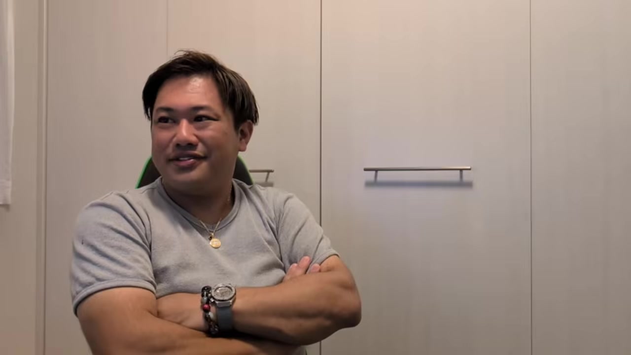 腕を組んで質問に答えるくに社長