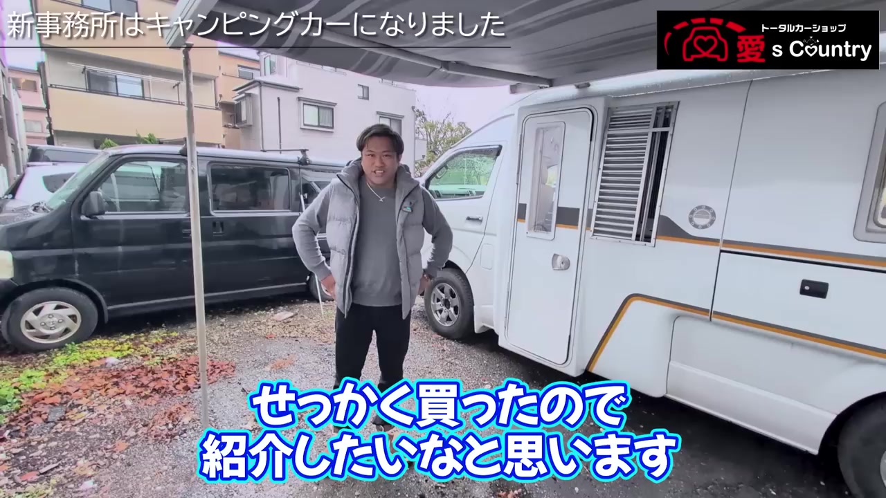 キャンピングカーの前に立つスタッフと白いキャブコン