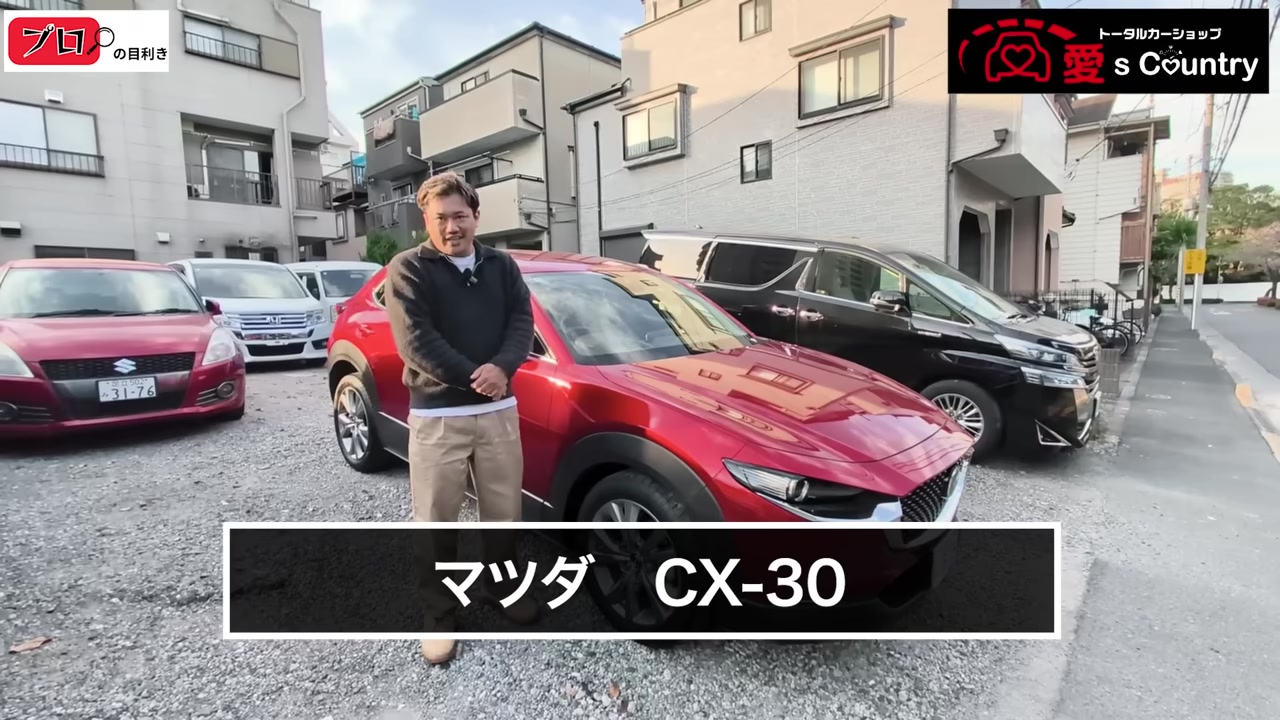 赤いマツダCX-30の斜め前と説明するくに社長