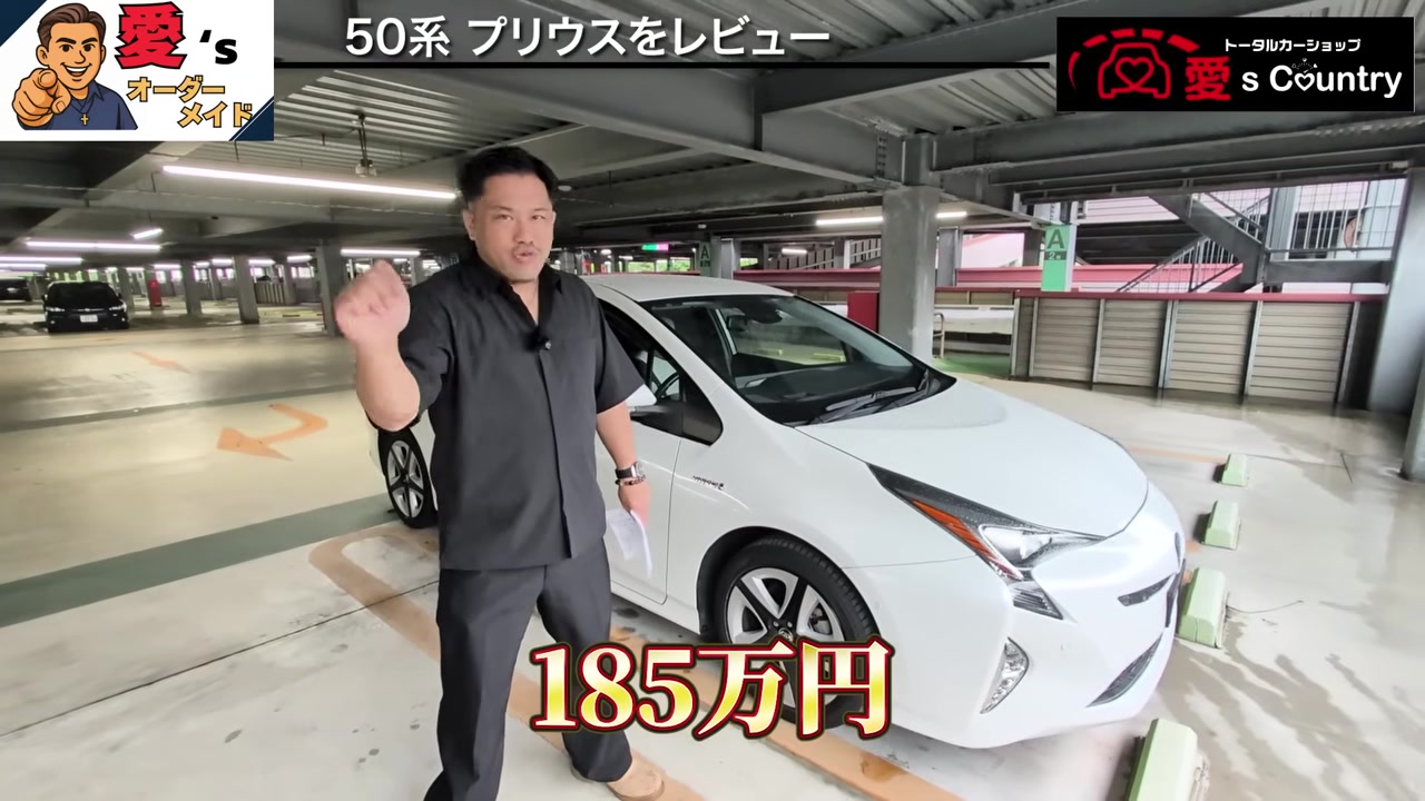白いプリウスの隣で総額を説明する社長