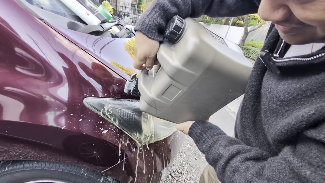 水タンクでヘッドライトの泡を流す様子